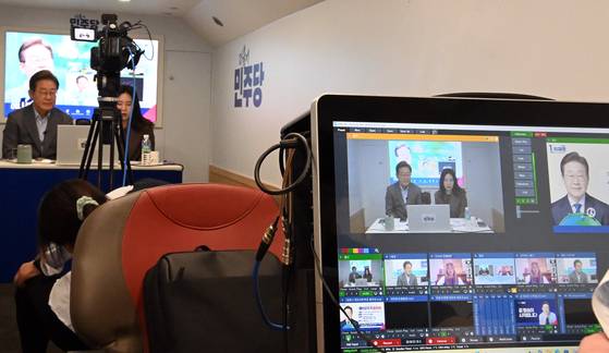 Democratic Party presidential candidate Lee Jae-myung, left, participates in a livestream encouraging overseas voting during his commute to a campaign event in Uijeongbu, Gyeonggi, on May 20. [KIM SEONG-RYONG]