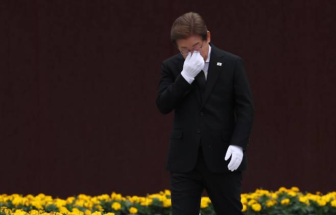 이재명 더불어민주당 대선 후보가 23일 경남 김해시 진영읍 봉하마을을 방문해 노무현 전 대통령 묘역 참배 및 헌화를 마친 뒤 눈물을 훔치고 있다. 공동취재단