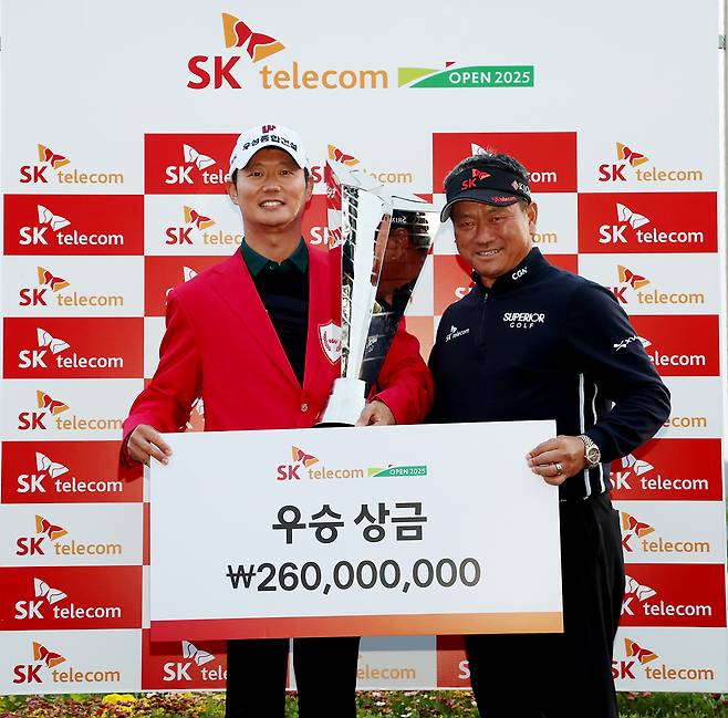 지난 18일 제주도 서귀포시 핀크스CC에서 끝난 KPGA투어 SK텔레콤 오픈에서 우승한 엄재웅에게 트로피를 전달하며 격려하고 있는 최경주(오른쪽). KPGA