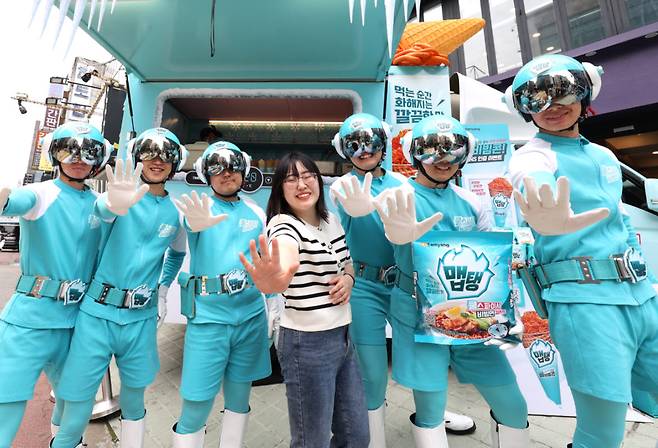 삼양식품이 진행한 '출동! 후레시맵' 캠페인 현장. 형광 민트색 수트를 입은 요원들이 참가자와 함께 활기찬 포즈를 취하고 있다. 사진제공=삼양식품