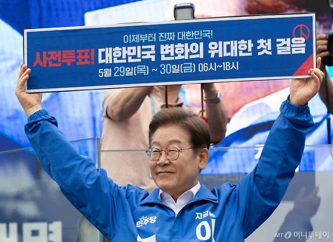 [양산=뉴시스] 조성우 기자 = 이재명 더불어민주당 대선후보가 22일 경남 양산시 양산워터파크공원에서 열린 집중유세에서 손팻말을 들고 사전투표 독려 퍼포먼스를 하고 있다. (공동취재) 2025.05.22. photo@newsis.com /사진=