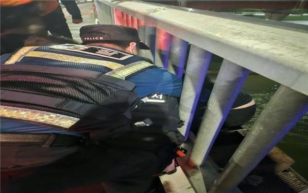 지난 18일 새벽 성수대교 난간에 걸터앉아 있던 여성을 경찰과 시민이 구조하고 있다. 성동경찰서 제공