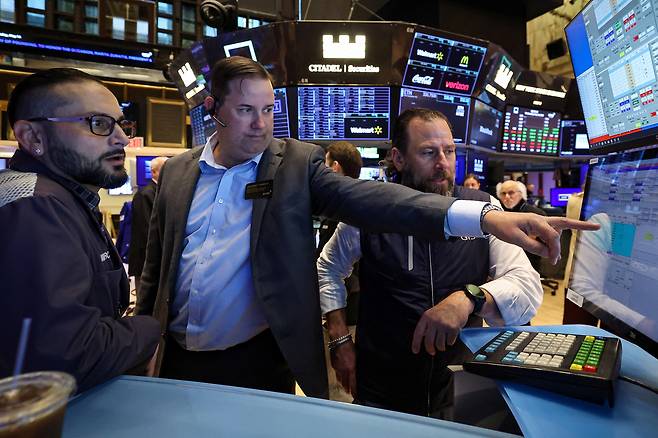 14일(현지시간) 미국 뉴욕시 뉴욕증권거래소(NYSE)에서 트레이더들이 바닥에서 일하고 있다. [로이터]
