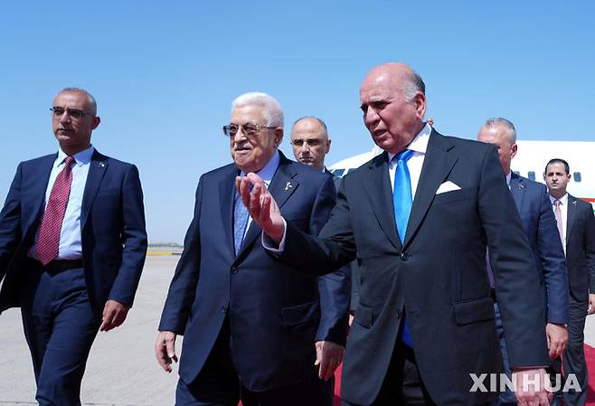 [ 바그다드(이라크)=신화/뉴시스] 5월 17일 바그다드 정상회의에 참석한 팔레스타인의 마무드 압바스 대통령 (왼쪽 가운데)을 후세인 이라크 외무장관(오른 쪽)이 공항에서 영접해 안내하고 있다. 2025. 05.23.