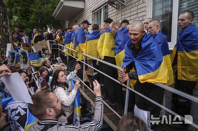 [우크라이나=AP/뉴시스] 5월 6일 우크라이나의 장소 미상 지역에서 러시아와의 포로 교환을 통해 석방된 우크라이나 군인들에게 실종되거나 억류 중인 군인 가족들이 사진을 보여주며 생사를 확인하고 있다. 2025.05.23.