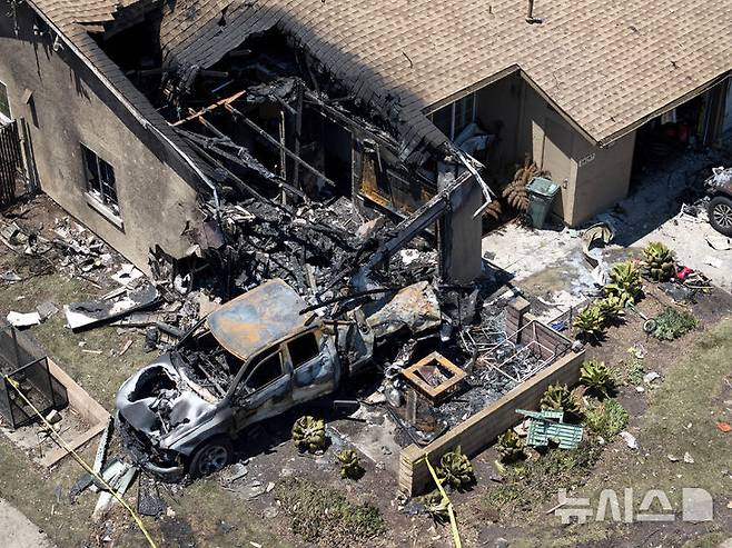 [샌디에이고=AP/뉴시스] 22일(현지 시간) 미국 캘리포니아주 샌디에이고 주택가에 개인 비행기가 추락한 사고가 발생해 주택이 파손돼 있다. 2025.05.23.