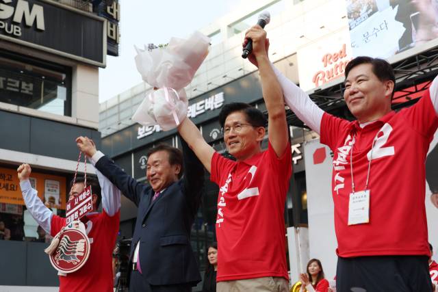 김문수 국민의힘 대선 후보가 22일 경기 광명시 철산로데오거리에서 열린 유세에서 꽃다발을 들고 손학규 전 바른미래당 대표와 함께 시민들에게 인사하고 있다. 연합뉴스