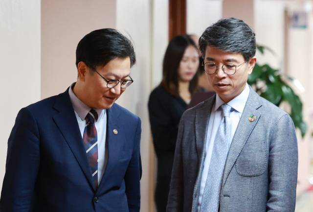 김범석 기획재정부 장관 직무대행 1차관(왼쪽)과 김완섭 환경부 장관이 13일 정부서울청사에서 열린 국무회의에 참석하며 대화하고 있다. 연합뉴스.