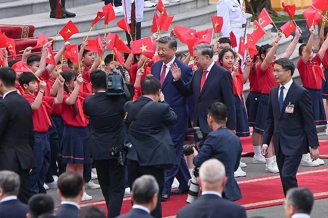 지난 4월 14일(현지시간) 베트남을 방문한 시진핑 중국 국가주석이 또 럼 베트남 공산당 서기장과 환영 인파 사이를 걸어가고 있다. 베트남 정부 포털사이트