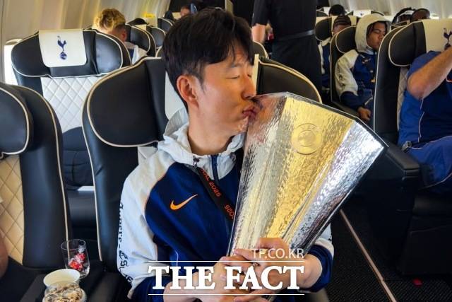 토트넘 손흥민이 22일(한국시간) UEFA 유로파리그 우승 후 런던으로 돌아오는 구단 전용기 안에서 트로피에 입을 맞추고 있다. /토트넘 소셜미디어