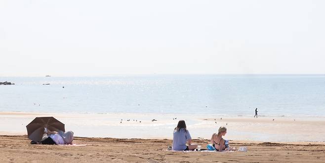 인천의 낮 최고기온이 영상 26도를 넘은 지난 22일 인천 중구 을왕리 해수욕장에서 외국인 관광객 등이 일광욕을 즐기고 있다. 기상청은 올여름(6~8월) 평년보다 기온이 올라가고, 장마도 더 심할 것으로 예측했다. /뉴시스