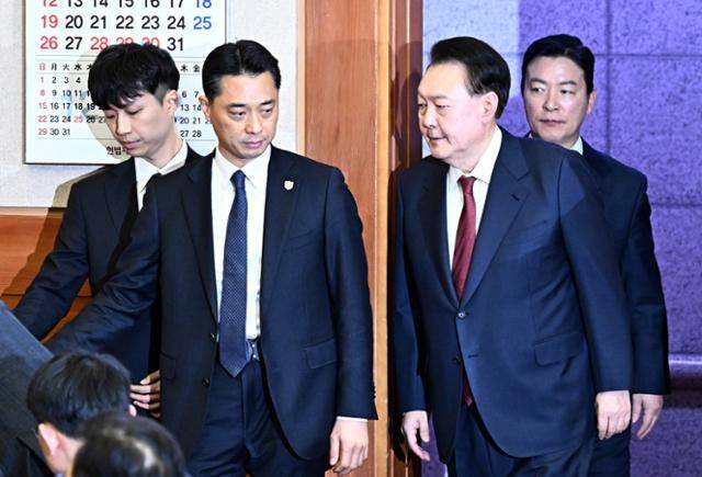 내란 우두머리 혐의로 구속된 윤석열 전 대통령이 1월 23일 오후 서울 종로구 헌법재판소에서 열린 탄핵 심판 4차 변론기일에 출석하고 있다. 김성훈 대통령경호처 차장이 윤 전 대통령을 경호하고 있다. 헌법재판소 제공