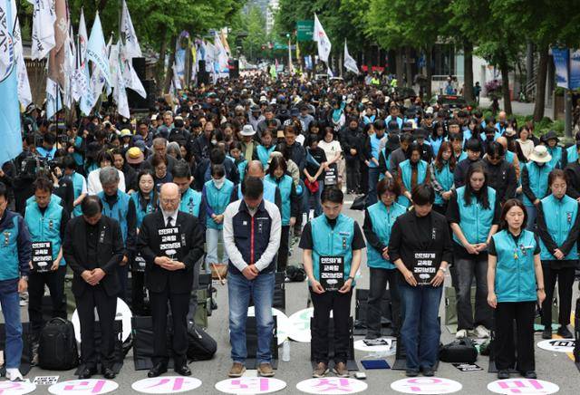 24일 서울 종로구 고궁박물관 서측에서 열린 '전국교직원노동조합 창립 36주년 전국교사결의대회'에서 참가자들이 최근 제주도의 한 중학교에서 교사가 사망한 사건과 관련해 고인을 추모하며 묵념하고 있다. 연합뉴스