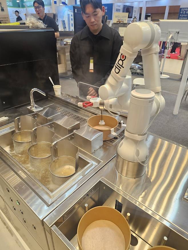 A noodle-cooking robot developed by commercial kitchen appliances company Dipo automatically places noodles into a boiler, takes them out and serves them in a bowl. (Choi Jae-hee/The Korea Herald)