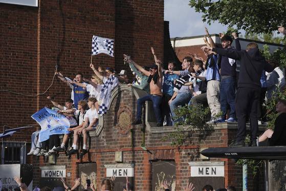 Tottenham Hotspur fans gather on rooftops to get a better view of the players during the victory parade on May 23. [AP/YONHAP]