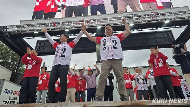 김문수 국민의힘 대선 후보가 24일 경북 칠곡군 왜관역 광장에서 정희용 의원과 함께 만세를 하고 있다. 임현범 기자