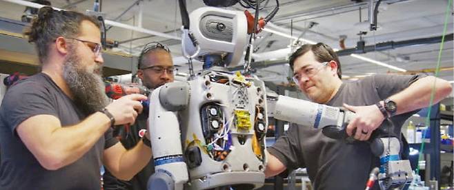 현대자동차그룹의 로봇 전문 계열사 보스턴다이내믹스 엔지니어들이 휴머노이드 ‘올 뉴 아틀라스’를 정비하고 있다. (사진=현대차그룹)