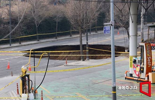 지난 24일 서울 강동구 대명초등학교 인근 사거리에서  4개차로에 걸친 '대형 싱크홀(땅꺼짐)' 이 발생했다. 25일 사고 현장 주변이 통제되고 있다. 싱크홀에는 승용차 1대와 오토바이 1대가 빠졌으며, 승용차 탑승자 1명은 인근 병원으로 이송됐다. 현재 싱크홀 아래에는 오토바이 운전자 1명이 매몰돼 있다. 깊이는 30m로 추정된다. 2025. 03. 25 윤동주 기자