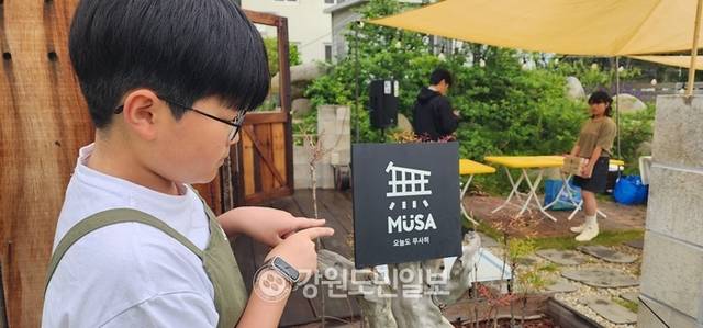 ▲ 최북단 고성군 죽왕면 자작도 해변 안길에서 ‘자작자작 야시장’이 열려 동네잔치 분위기를 연출하며 주말을 맞아 찾아온 관광객들에게 특별한 추억을 전했다. 자작도 해변 안길에서 무사를 운영하는 주인장의 아들이 이날 야시장을 도우러 나와 앙증맞은 문패를 가리키고 있다.