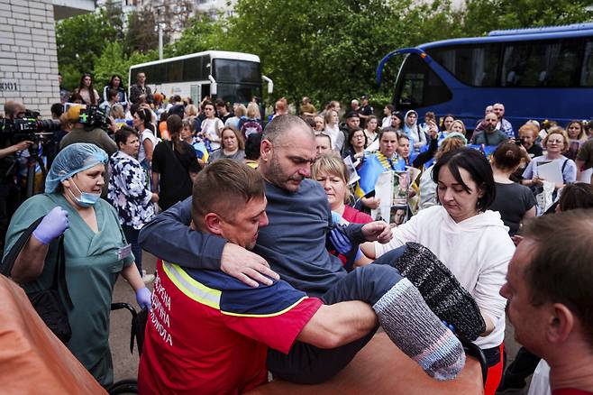 고향 품으로 돌아온 우크라 부상병 24일(현지시간) 우크라이나 체르니히우에서 러시아와 우크라이나 간 포로 교환으로 풀려난 우크라이나 부상병을 의료진이 옮기고 있다. AP연합뉴스