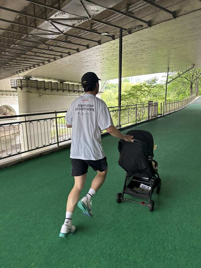 ‘기부 마라톤 2025 라이트업! 키즈레이스’ 참가자인 백종화씨가 24일 서울 강남구 대치유수지체육공원에서 유모차를 끌며 달리고 있다. 기자의 옆을 지나친 그는 선두 그룹에서 뛰었다.