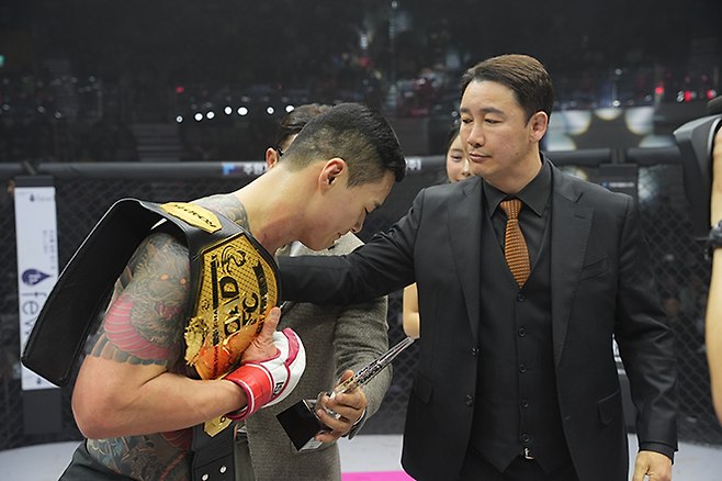 제8대 로드FC 미들급 챔피언 황인수가 2025년 3월 서울 장충체육관에서 통합 챔피언 등극 및 타이틀 1차 방어 성공 후 정문홍 대한MMA총협회장한테 인사하고 있다. 사진=세계격투스포츠협회
