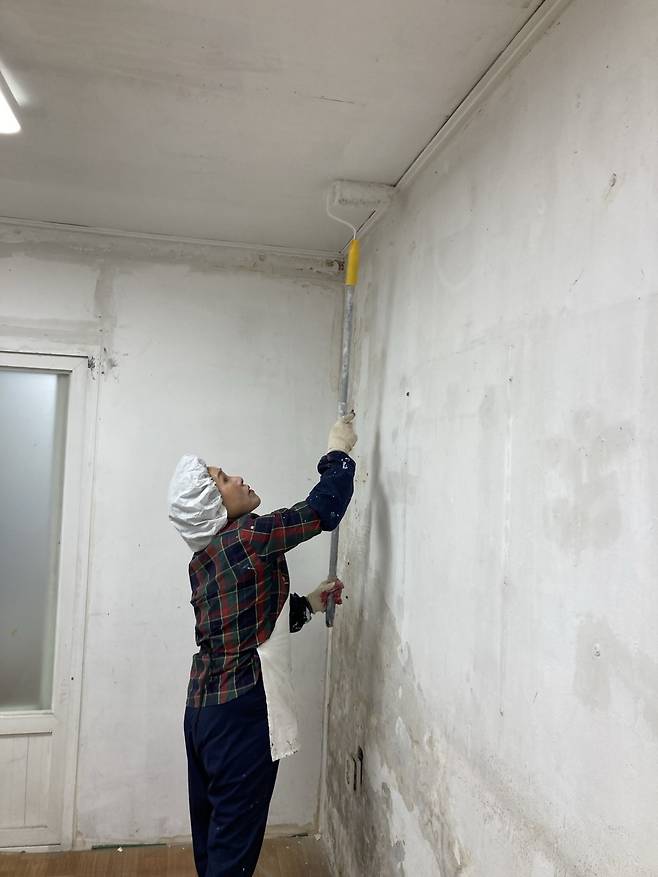 페인트칠을 하고 있는 안란자 여사. 손인규 기자