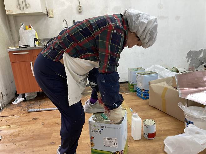 능숙하게 페인트통 뚜껑을 따고 있는 안란자 여사. 손인규 기자
