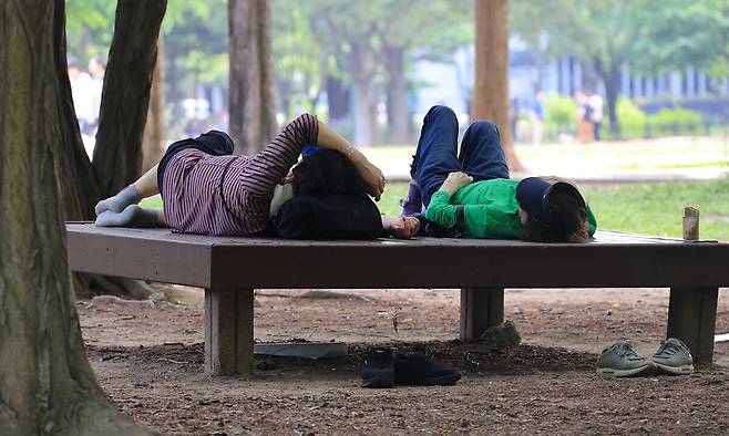 지난 21일 서울 성동구 서울숲에서 시민들이 그늘에서 휴식을 취하고 있다. 연합뉴스&nbsp;
