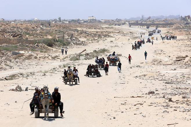 25일(현지시간) 팔레스타인 피란민들이 북부 가자지구에서 남쪽으로 해안 알 라시드 도로를 따라 이동하고 있다. (사진=AFP)