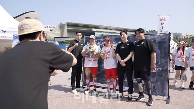 25일 서울 여의도공원 무한도전마라톤 행사장에서 열린 국군 영웅 감사 챌린지에서 하재헌(맨 오른쪽) 예비역 중사, 이한(오른쪽 둘째)·이찬호(맨 왼쪽) 예비역 병장이 시민들과 기념 촬영하고 있다. (사진=국군예우사업회)