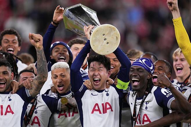 토트넘 홋스퍼의 손흥민이 21일(현지 시간) 스페인 빌바오의 산 마메스 스타디움에서 열린 2024-25 유럽축구연맹(UEFA) 유로파리그(UEL)에서 우승한 뒤 동료들과 함께 트로피를 들어 올리고 있다. 토트넘은 결승전에서 맨체스터 유나이티드를 1-0으로 꺾고 우승을 차지했으며, 손흥민은 생애 첫 우승컵을 들어 올렸다.  AP 뉴시스