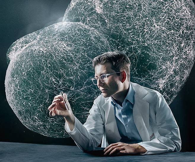 미 스팬퍼드대의 세르지우 파스카 교수가 미니 뇌가 들어있는 실험 용기를 보고 있다. 배경은 미니 뇌. 파스카 교수는 인간 미니 뇌를 쥐의 뇌에 이식해 하나가 되게 하는 데 성공했다. / 사진 미 스탠퍼드대