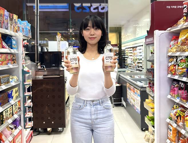 모델이 GS25가 새롭게 출시한 선양오크소주병을 들고 포즈를 취하고 있다.