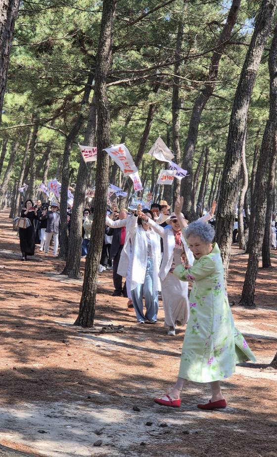 생의 한가운데에서 자신의 죽음을 잔치로 만든 배우 박정자(맨 앞). 25일 강릉에서 빨간 구두를 신고 자신의 장례 행렬 맨앞에서 웃으며 춤을 추고 있다. 이지영 기자
