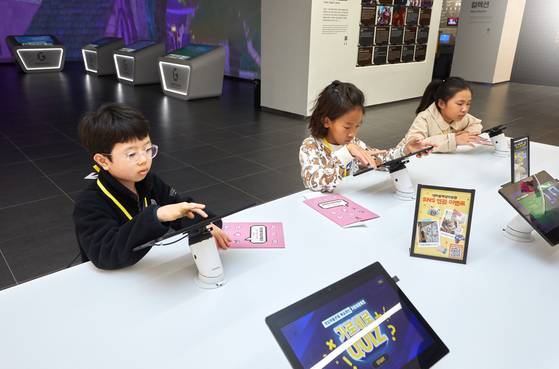 최수혁·이성빈·정서우(왼쪽부터) 학생기자가 라이브러리에 마련된 태블릿으로 넷마블게임박물관 전시 관련 퀴즈를 풀고 있다.