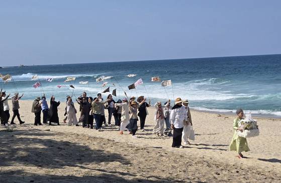 25일 강릉 순포해변에서 열린 배우 박정자의 '사전 장례식'. 상여를 든 박정자 뒤로 그의 지인 150여 명이 만장을 펄럭이며 따라가고 있다. 이지영 기자