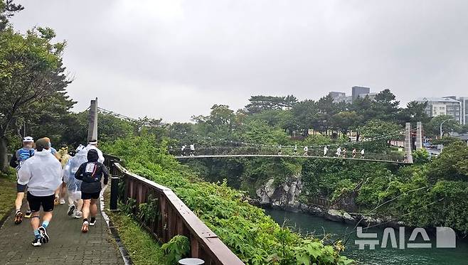 [제주=뉴시스] 임재영 기자 = 제주국제울트라마라톤대회 참가 선수들이 24일 오전 제주시 용연 구름다리를 지나고 있다. 이들은 50㎞, 100㎞, 200㎞ 등 3개 종목에서 자신의 한계에 도전하는 경기를 펼친다. 2025.05.26. ijy788@newsis.com