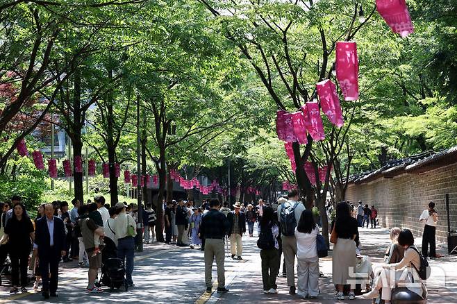 [서울=뉴시스] 조수정 기자 = 화창한 날씨를 보인 25일 서울 중구 덕수궁 돌담길에서 시민들이 거리 공연을 즐기고 있다. 2025.05.25. chocrystal@newsis.com