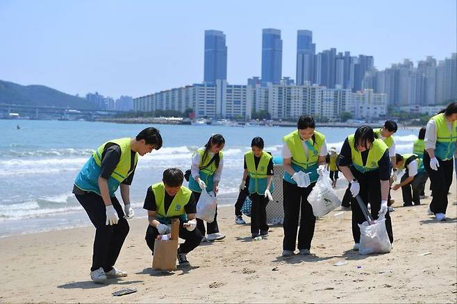 [부산=뉴시스] 직장인청년봉사단(ASEZ WAO)은 부산 수영구 광안리해수욕장에서 '2040 플라스틱 프리' 캠페인을 진행했다. (사진=ASEZ WAO 제공) 2025.05.26. photo@newsis.com *재판매 및 DB 금지