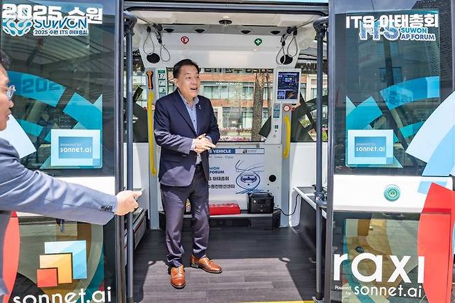 [수원=뉴시스] 이재준 수원시장이 26일 오전 수원컨벤션센터 앞에서 전시돼 있는 프랑스산 '나브야'(NAVYA) 자율주행 셔틀차량 탑승구 앞에서 소감을 말하고 있다. 이번 행사는 '2025 수원 ITS 아태총회'의 기술 시연 프로그램의 하나로 마련됐다. 2025.05.26. (사진=수원시 제공) photo@newsis.com *재판매 및 DB 금지