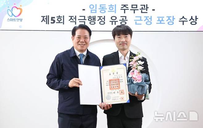 [안양=뉴시스] 최대호 시장(사진 왼쪽)이 정부를 대신해 임동희 주무관에게 근정포장을 전달한 후 기념 촬영을 하고 있다. (사진=안양시 제공). 2025.05.26.photo@newsis.com