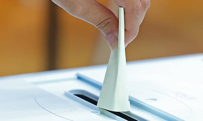 투표소를 찾은 유권자가 투표함에 투표용지를 넣고 있다. 연합뉴스