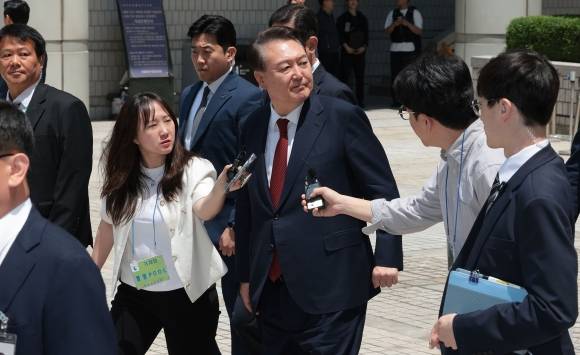 윤석열 전 대통령이 26일 서울 서초구 서울중앙지방법원에서 열린 내란 우두머리 혐의ㆍ직권남용 권리행사 방해 혐의 사건 5차 오전 공판을 마친 뒤 지지자들을 바라보며 차량으로 향하고 있다. 2025.5.26 사진공동취재단