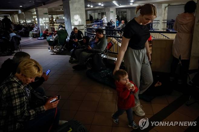 25일(현지시간) 러시아의 공습을 피해 지하철 대피소로 피신한 우크라이나 키이우 시민들 [로이터 연합뉴스]
