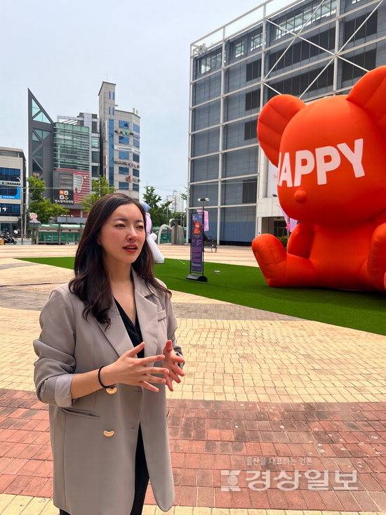 ▲ 김소정 울산국제아트페어(주) 대표가 롯데백화점 울산점 샤롯데 광장에 설치된 임지빈 작가의 곰 형태 대형 풍선 조형물 앞에서 포즈를 취하고 있다. 울산국제아트페어 제공