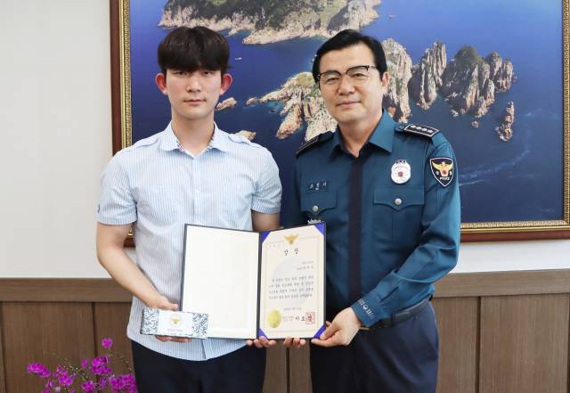 한밤중 해안가를 산책하다 바다에 빠진 여성을 구조한 통영고등학교 2학년 박지한(왼쪽) 군에게 경찰청장 상장이 전수됐다. 통영경찰서 제공