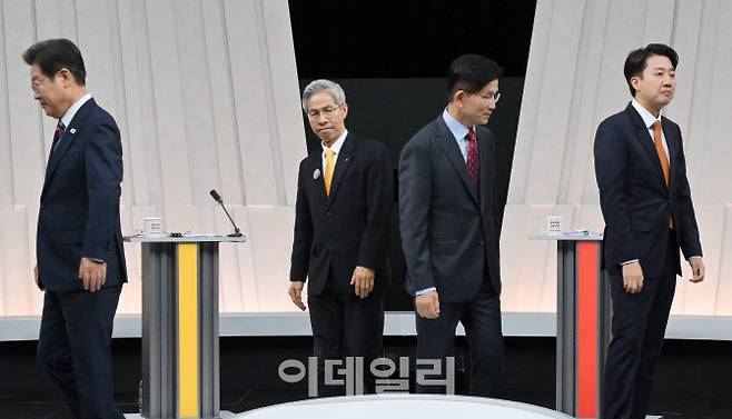 [서울=뉴시스] 국회사진기자단 = 27일 오후 서울 마포구 상암동 MBC 스튜디오에서 열린 중앙선거방송토론위원회 주관 제21대 대통령선거 3차 후보자토론회 시작에 앞서 각 정당 대선후보들이 기념촬영을 마친 뒤 자리로 돌아가고 있다. 왼쪽부터 이재명 더불어민주당, 권영국 민주노동당, 김문수 국민의힘, 이준석 개혁신당 대선후보. 2025.05.27. photo@newsis.com