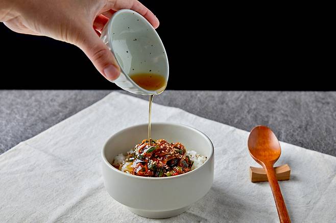 참기름을 꼬막비빔밥에 넣고 있다. 참기름과 팜유, 코코넛유 등 옥타노산(OA)이 풍부한 음식이 유방암 환자의 뼈통증 완화에 좋다는 중국의 연구 결과가 대한통증학회지에 실렸다. 옥타노산(OA)은 중간사슬(중쇄) 지방산에 속한다.[사진=게티이미지뱅크]