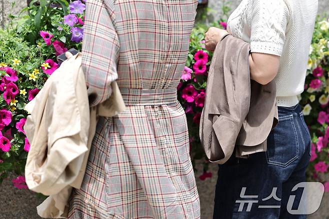 26일 오후 서울 청계광장에서 시민들이 벗은 겉옷을 손에 들고 올해 마지막 봄을 즐기고 있다. 기상청은 내일과 모레 동쪽 지방을 중심으로 요란한 소나기가 지나가고 주 후반에는 30도 안팎의 더위가 나타날 것으로 예보했다. 2025.5.26/뉴스1 ⓒ News1 신웅수 기자